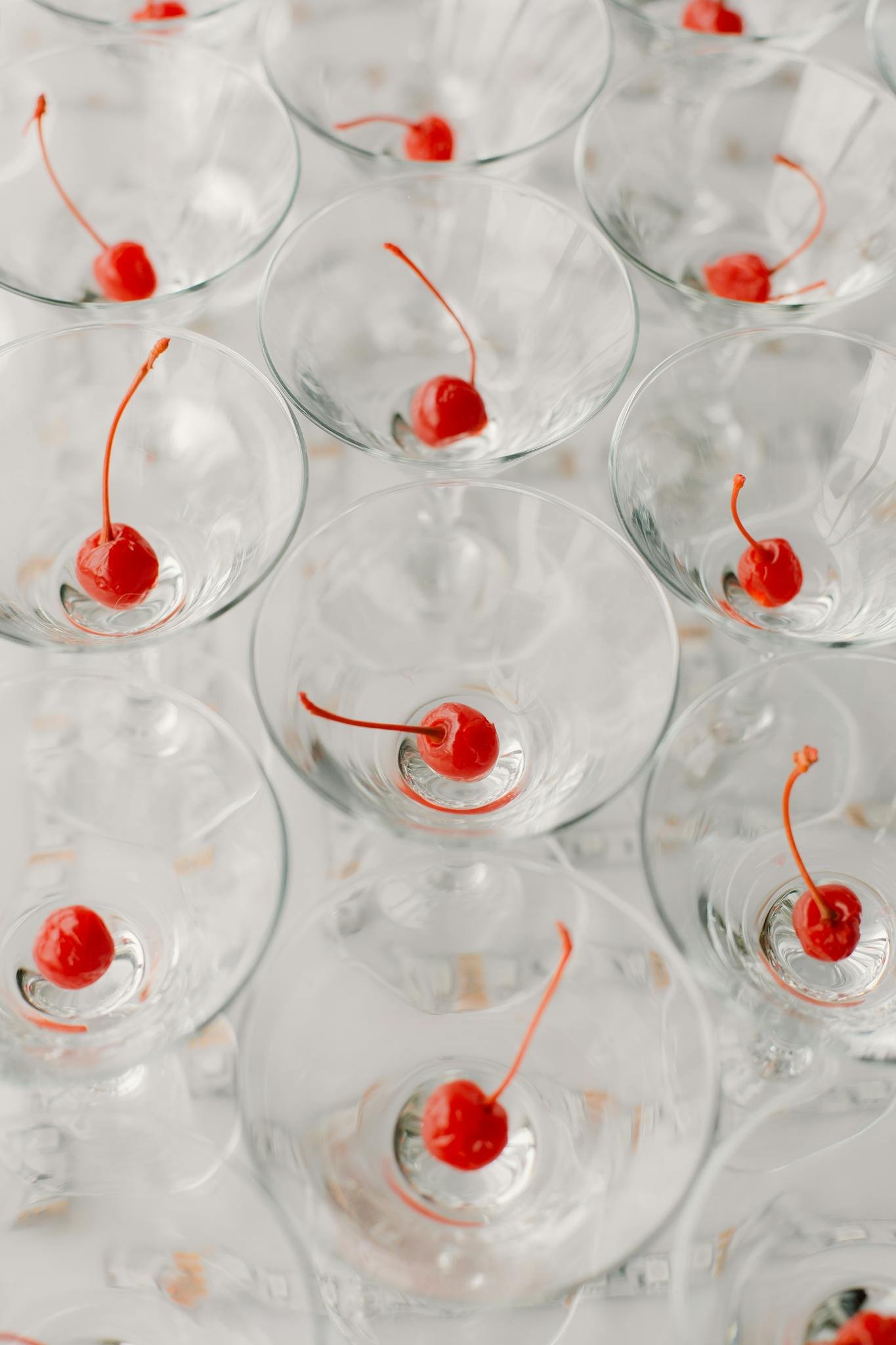 Refreshing alcoholic drinks with cherries served on white table